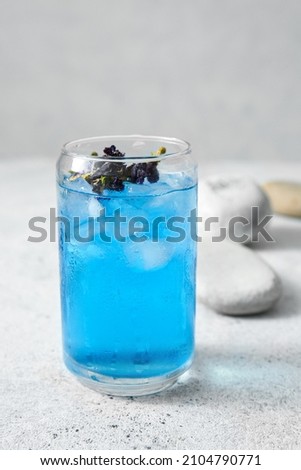 Glass of organic blue tea on light background, closeup