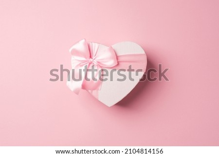 Top view photo of valentine's day decorations heart shaped giftbox with pink ribbon bow on isolated pastel pink background with copyspace Royalty-Free Stock Photo #2104814156