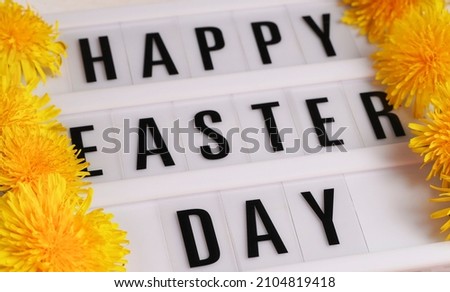   Happy Easter Day greeting card with sping yellow dandelions flowers on rustic white wooden background. Creative frame border Happy Easter Day card with Stylish text frame