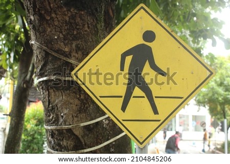 traffic signs, pedestrian paths against tree trunks and sparkling sunlight