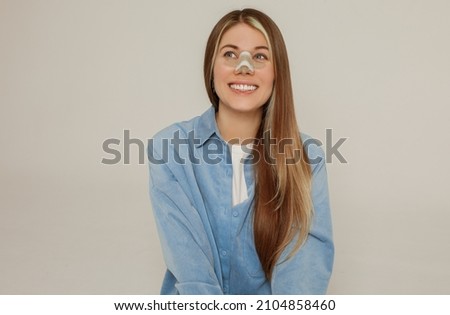A young beautiful woman with a bandage on her nose after rhinoplasty Royalty-Free Stock Photo #2104858460