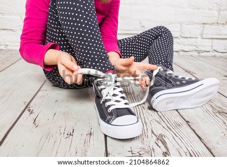 learning how to bind shoes Royalty-Free Stock Photo #2104864862