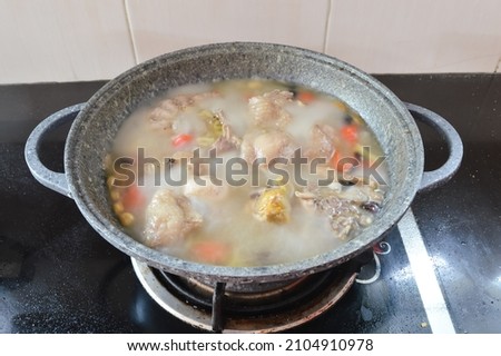 Boiled chicken in a pot broth of boiling water
