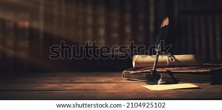 old quill pen with inkwell and papers on wooden desk against vintage bookcase. retro style. banner copy space Royalty-Free Stock Photo #2104925102