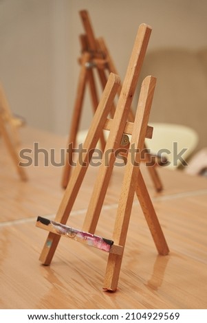 small wooden canvas easel stands on the table