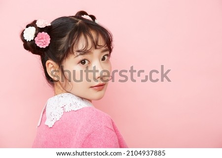 Girly portrait of young Asian woman on pink background