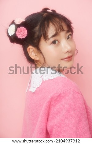 Girly portrait of young Asian woman on pink background shot by soft focused
