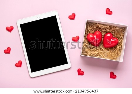 digital tablet for chooses gifts, makes purchase, box, two red candles hearts on pink table Top view Flat lay Holiday shopping list, Happy Valentine's day, party, online shop concept Mock up