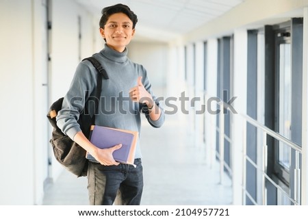 Happy indian male student at the university Royalty-Free Stock Photo #2104957721