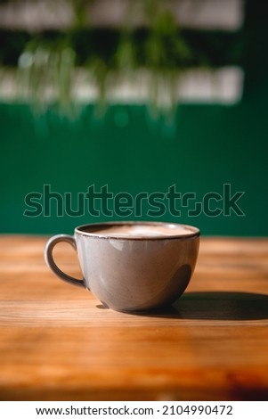 Coffee cup with cream or milk, on beautiful wooden background. Great picture for baner or menu