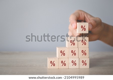 Hand arranging wood block stacking with icon percent symbol upward direction,