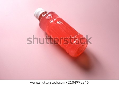 Bottle of homemade raspberry drink on the pink background Royalty-Free Stock Photo #2104998245