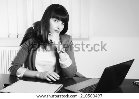 Black and white.Woman in a business suit. Business woman sitting at the table, working with the computer. Business, work, business woman - business concept girl. The idea about the woman's business.