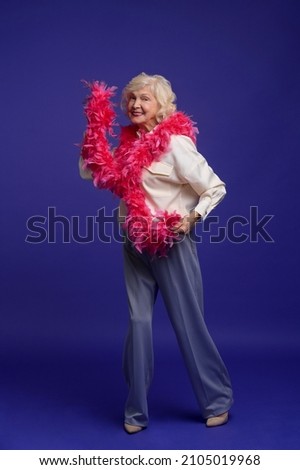 Energetic elegant woman with a feather boa on her shoulder Royalty-Free Stock Photo #2105019968