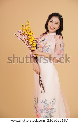Vietnamese young lady in traditional robe for Lunar New Year Festival Season Royalty-Free Stock Photo #2105023187