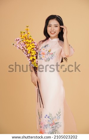 Vietnamese young lady in traditional robe for Lunar New Year Festival Season Royalty-Free Stock Photo #2105023202