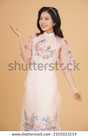Vietnamese young lady in traditional robe for Lunar New Year Festival Season Royalty-Free Stock Photo #2105023214