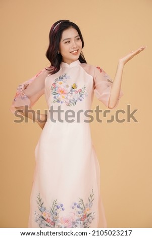 Vietnamese young lady in traditional robe for Lunar New Year Festival Season Royalty-Free Stock Photo #2105023217