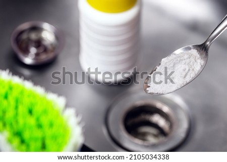 spoon with baking soda or sodium hydroxide powder, do it yourself, cleaning the kitchen sink Royalty-Free Stock Photo #2105034338