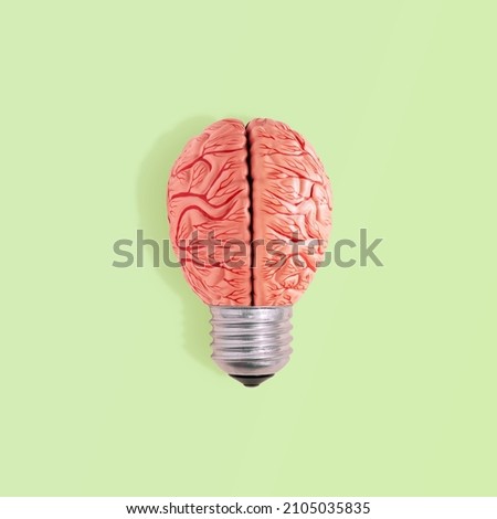 Abstract surreal conceptual wallpaper made with light bulb cap and model of human brain on isolated pastel green background. Brainstorming or knowledge icon. Minimal flat lay. Creative idea of lamp. Royalty-Free Stock Photo #2105035835