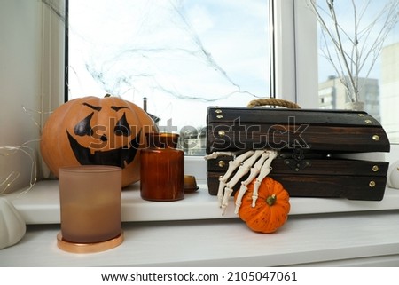 Different Halloween decor on windowsill indoors. Festive interior