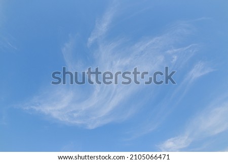 Thin white clouds on a blue background