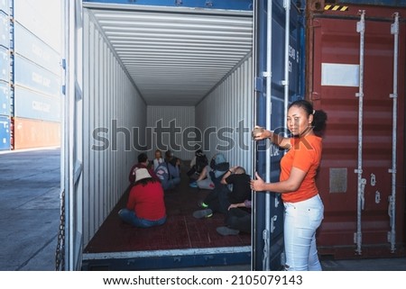 An African women Opening the door of a container, inside of which several people were sitting, to human trafficking and illegal immigration concept. Royalty-Free Stock Photo #2105079143