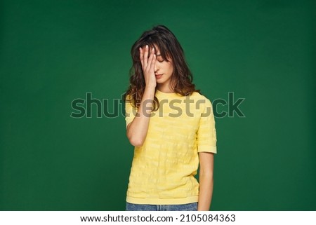 Facepalm gesture. Stressed tired young girl cover face by hand feel sorrow, shame for mistake on green studio background Royalty-Free Stock Photo #2105084363