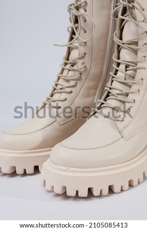 Women's white winter boots with fur with thick soles and laces. Advertising of the new collection of women's shoes 2022