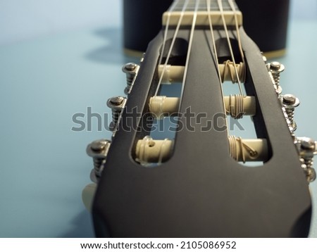 Black guitar on a blue background.