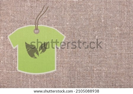 Green label, clothes made of natural fabrics, against a background of gray linen. copy space. High quality photo