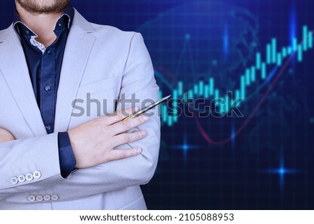 The graph of the growth of the stock market, against the background of a male businessman in a gray suit with crossed arms and a pen. Double exposure. High quality photo