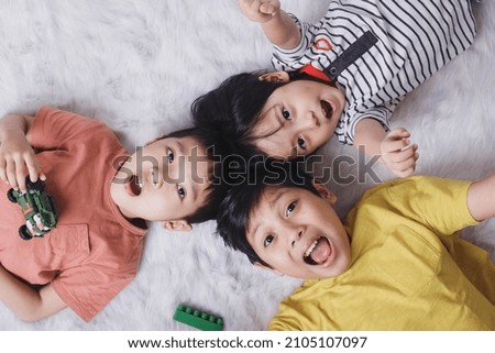 Close up top view of happy children showing their toys on white background