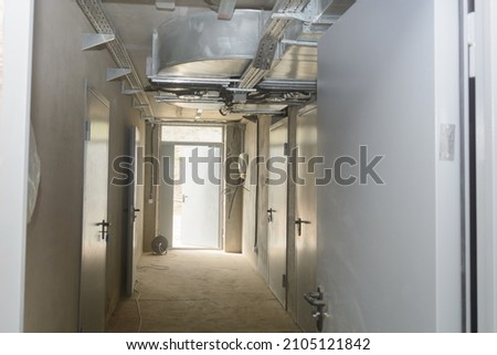 Corridor in an industrial building with fire doors and ventilation system. Selective focus. Royalty-Free Stock Photo #2105121842