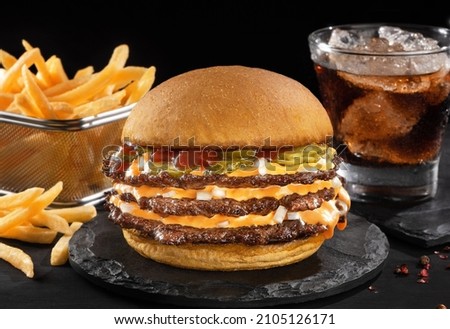 Smash burger with fries in black backgraund Royalty-Free Stock Photo #2105126171