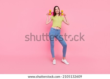 Full size photo of smiling cool hipster retro girl wear top showing belly hold skateboard isolated on pink color background