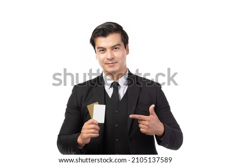 Handsome business man in black suit holding and finger pointing to credit card isolated on white background. Business, technology, ecommerce and online payment concept.