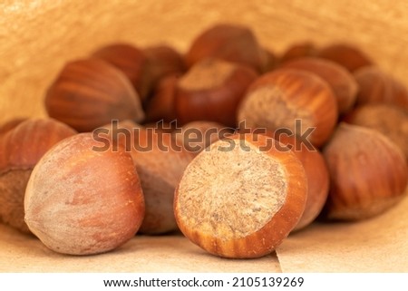 Several organic hazelnuts in a paper bag, close-up.