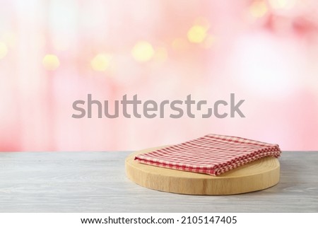 Empty wooden log  with red checked tablecloth on rustic table over beautiful bokeh background.  Valentines day concept mock up for design and product display.