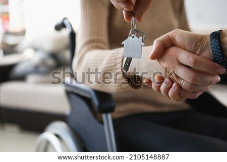 Realtor give keys from new accommodation to woman in wheelchair Royalty-Free Stock Photo #2105148887