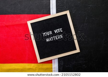 Letterboard sign with the words your vote matters with German flag on  black background