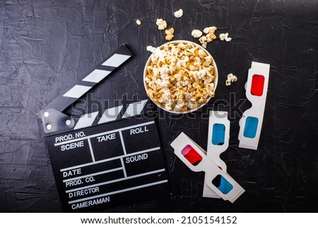 Cinema minimal concept. popcorn, 3d glasses clapper board on black background