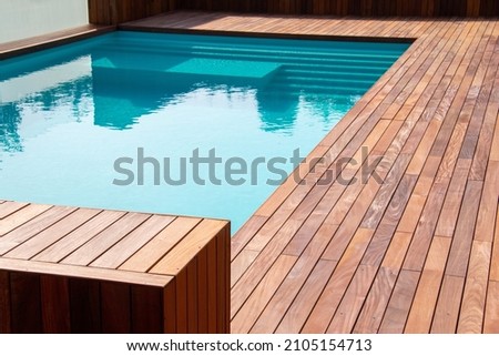 Hardwood ipe pool deck on direct sun heat, summer swimming pool decking design idea Royalty-Free Stock Photo #2105154713
