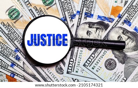 Background with dollar bills under a magnifying glass with the text JUSTICE. Financial concept