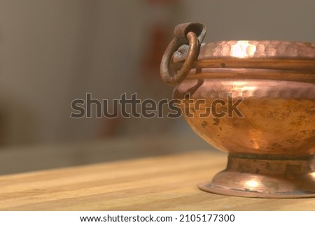 A partial photograph of a traditional and antique Copper vessel.