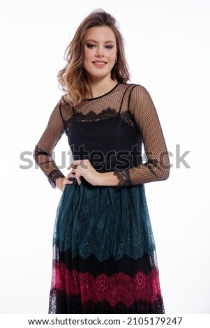 High fashion photo of a beautiful elegant young woman in a pretty triple black, red, green color dress with lace,   posing on white background. Slim figure, luxurious hair, shiny curls. Studio Shot