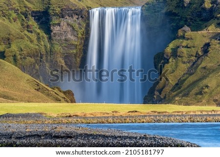Long exposure of Skogafoss waterfall in Iceland from the distance river