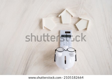 Piggy bank and home model and calculator with working capital management in put on the wood in the office, Loan for real estate and searching for buy house to family in the future concept.