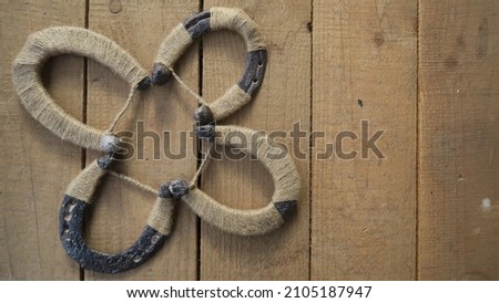 DIY handmade trefoil clover from horseshoes for your daily luck on a wooden background Royalty-Free Stock Photo #2105187947