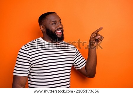 Profile side photo of young african man look point finger empty space select promo imagine game isolated over orange color background